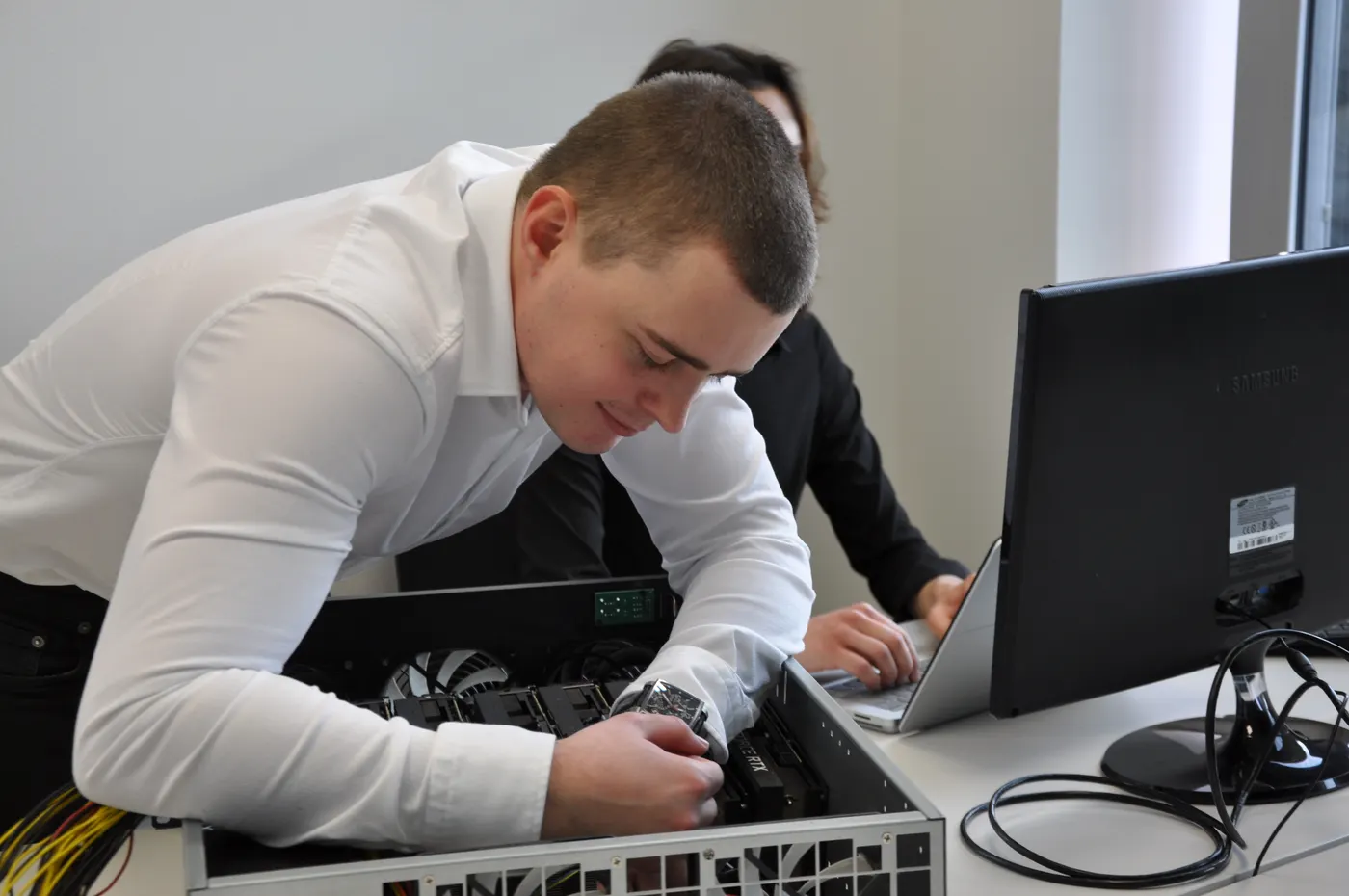 Inženýr Ollsoftu se sklání nad otevřeným serverem a pracuje na hardwaru